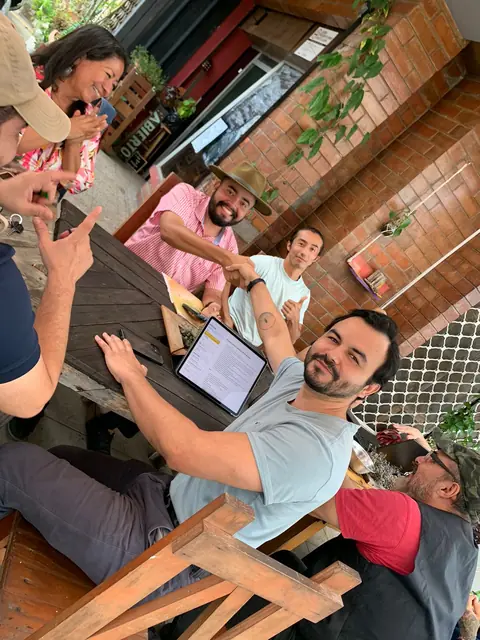 Integrantes del equipo de ACAXUAL se dan la mano en una reunión de trabajo