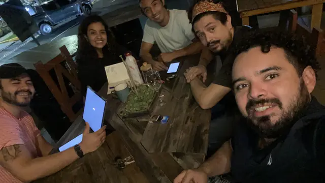 El equipo de ACAXUAL reunido en una mesa de trabajo con tabletas y notas